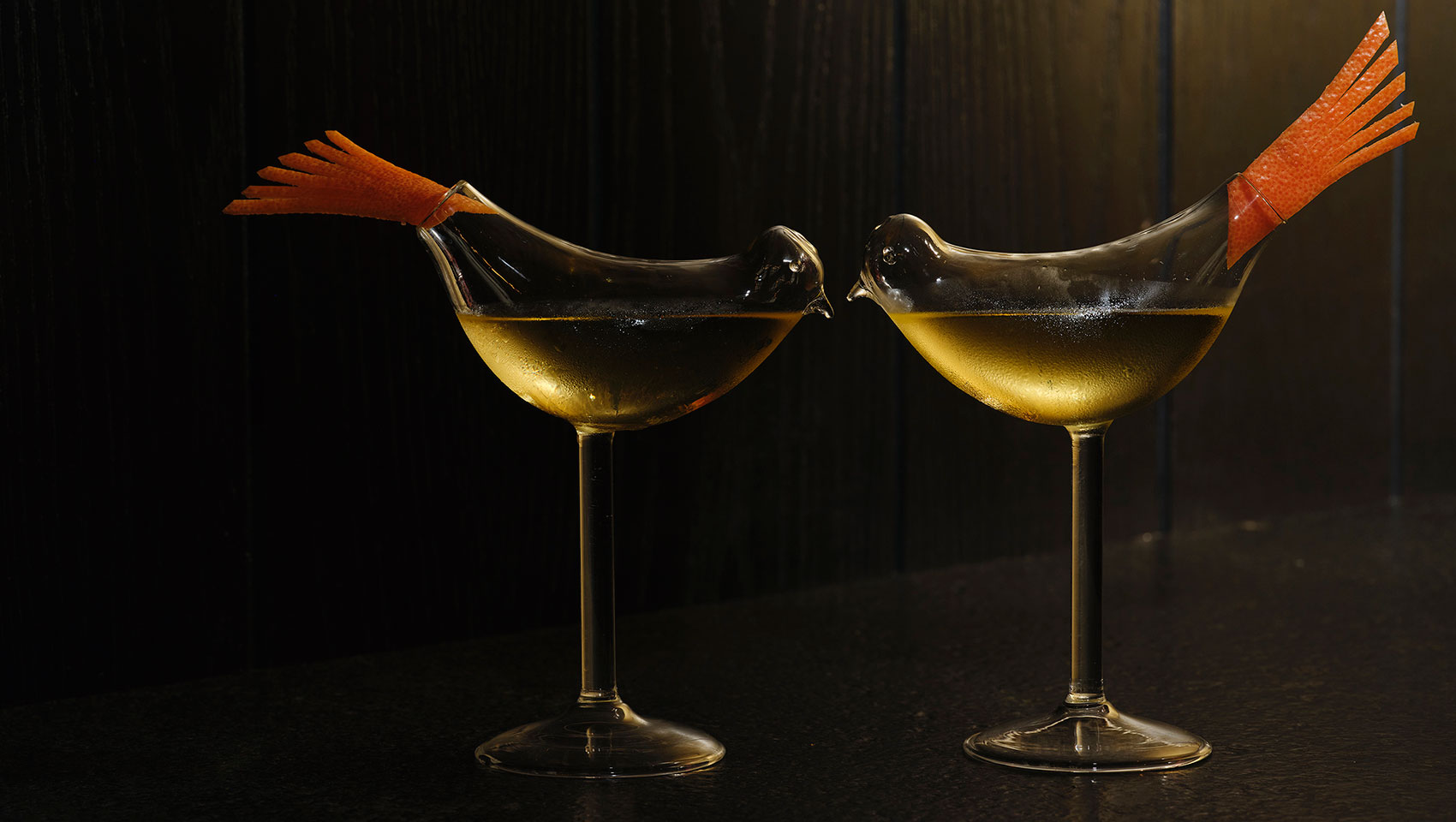 two cocktail glasses shaped as birds